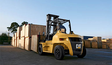 Operator Using a Large Cat IC Pneumatic Tire Forklift to Stack Boxes Outdoors